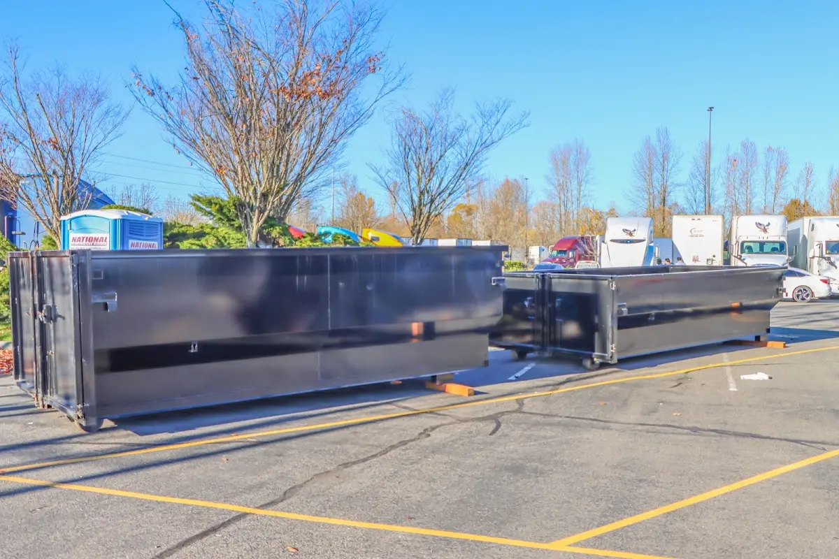 Professional dumpster rental service with roll-off container on residential driveway in La Puente